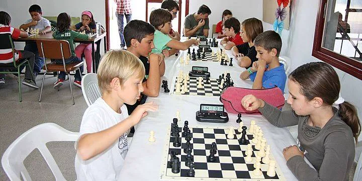 Niños concentrados en sus partidas durante una clase de ajedrez en la academia de Los Olivos