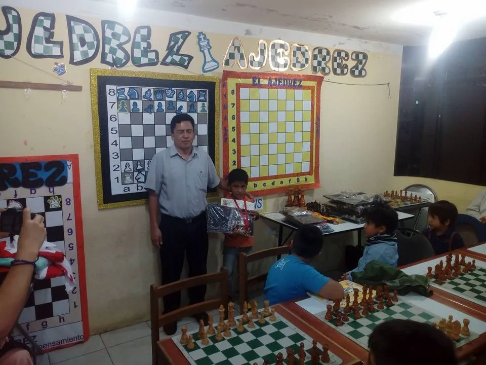 Aula de la academia de ajedrez en Los Olivos durante una premiación, con tableros murales didácticos